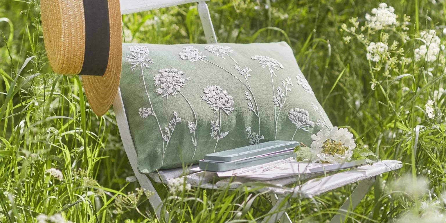 Coussin brodé Broderie Mirija dans l'herbe